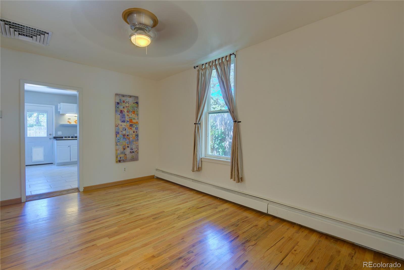2537 Ames Street Edgewater, CO 80214 - Photo 29 of 38 an empty room with wooden floor and windows