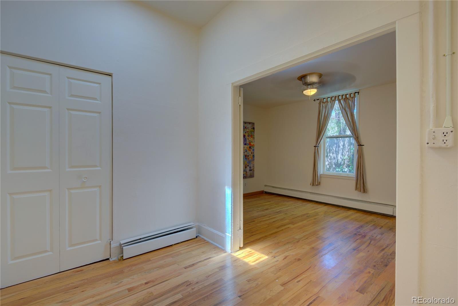2537 Ames Street Edgewater, CO 80214 - Photo 33 of 38 an empty room with wooden floor cabinet and door