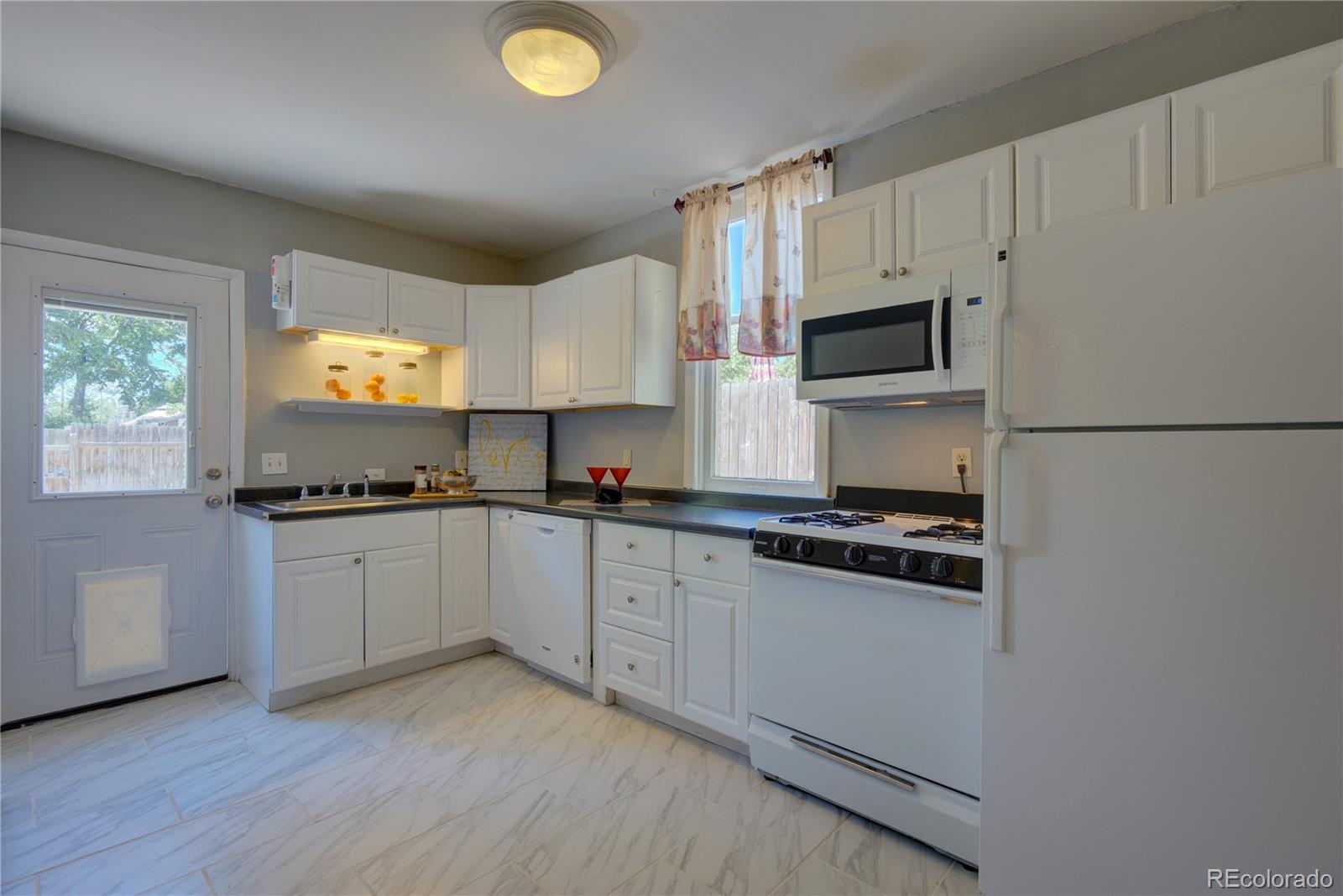 2537 Ames Street Edgewater, CO 80214 - Photo 34 of 38 a kitchen with stainless steel appliances a sink cabinets and a window