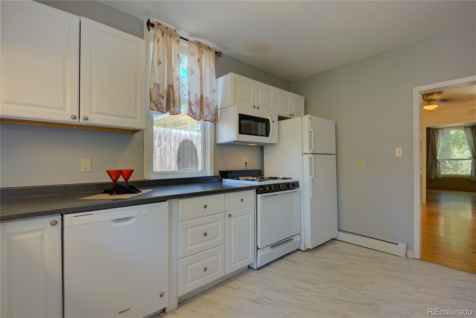 2537 Ames Street Edgewater, CO 80214 - Photo 36 of 38 a kitchen with granite countertop white cabinets and stainless steel appliances