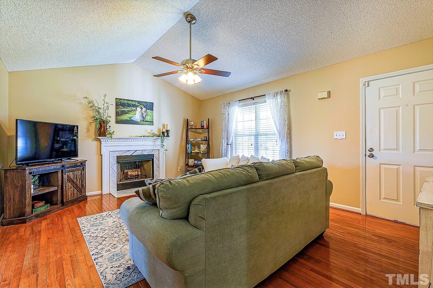 1001 Retriever Lane Raleigh, NC 27603 - Photo 11 of 50 a living room with furniture a flat screen tv and a fireplace