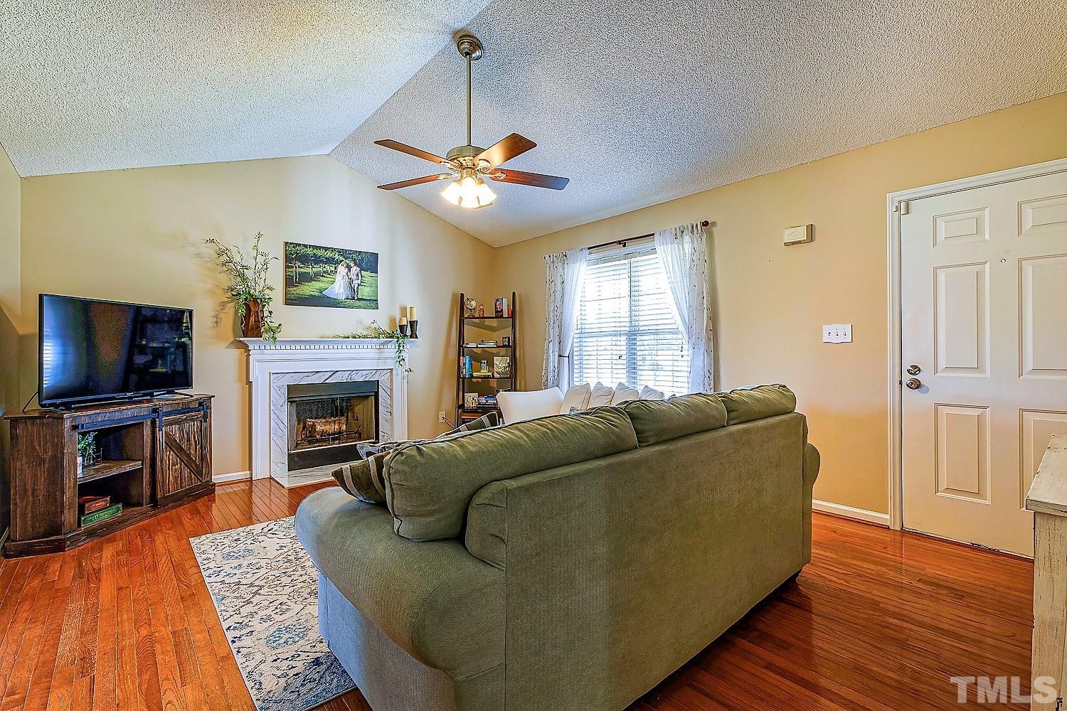 1001 Retriever Lane Raleigh, NC 27603 - Photo 12 of 50 a living room with furniture a flat screen tv and a fireplace