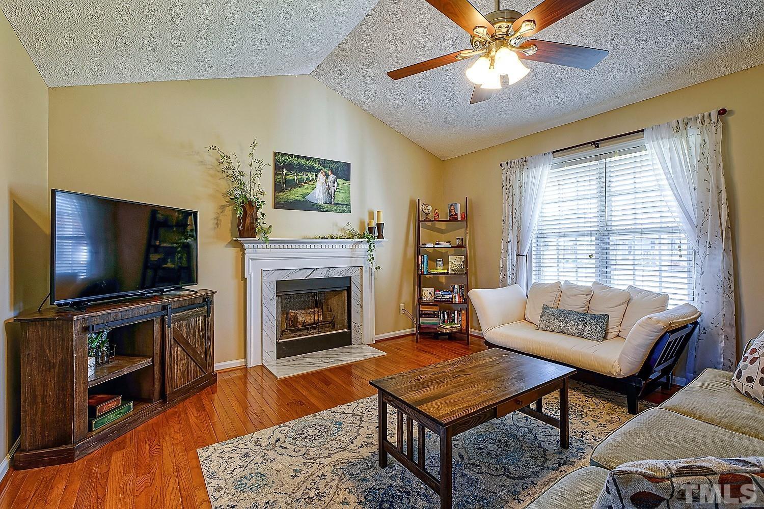 1001 Retriever Lane Raleigh, NC 27603 - Photo 13 of 50 a living room with furniture a flat screen tv and a fireplace
