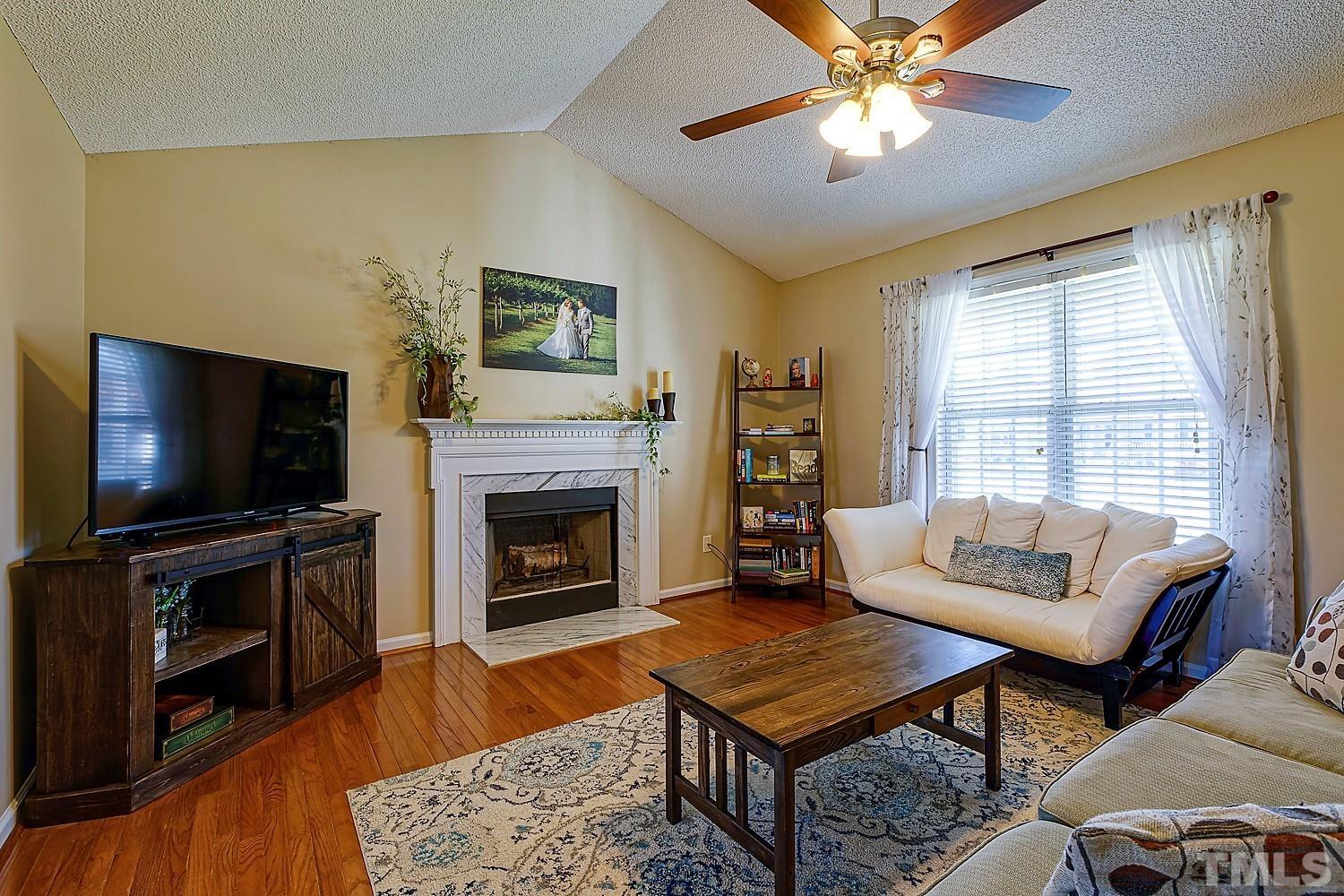 1001 Retriever Lane Raleigh, NC 27603 - Photo 14 of 50 a living room with furniture a flat screen tv and a fireplace