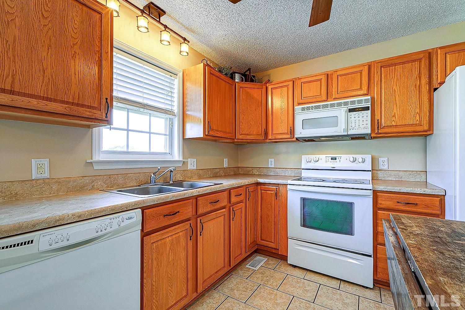 1001 Retriever Lane Raleigh, NC 27603 - Photo 21 of 50 a kitchen with stainless steel appliances granite countertop a sink stove and microwave