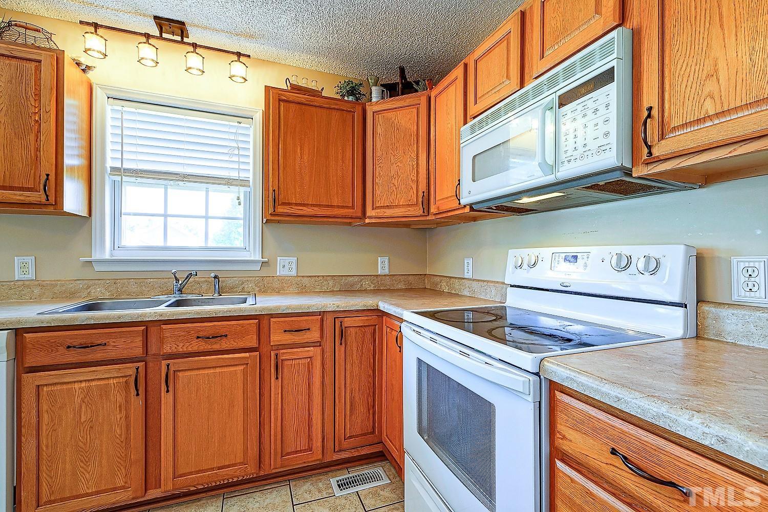1001 Retriever Lane Raleigh, NC 27603 - Photo 23 of 50 a kitchen with stainless steel appliances granite countertop a sink and cabinets