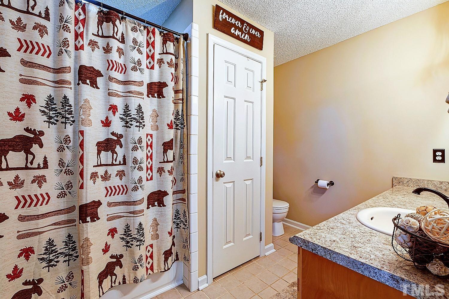 1001 Retriever Lane Raleigh, NC 27603 - Photo 30 of 50 a bathroom with a granite countertop sink and a shower curtain
