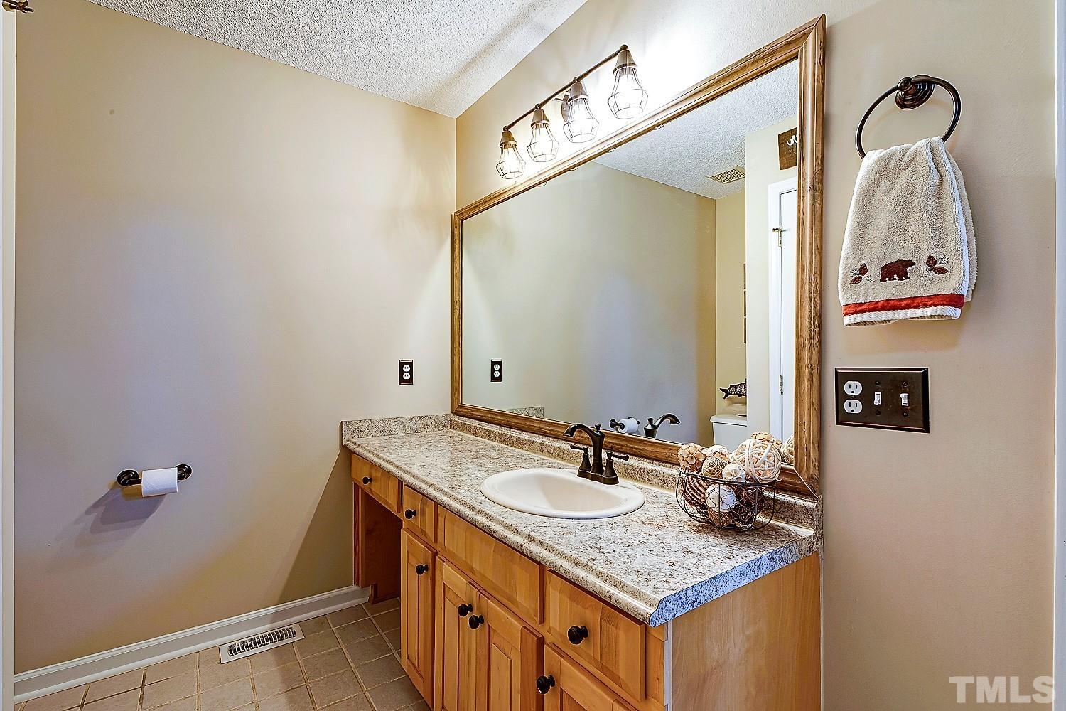 1001 Retriever Lane Raleigh, NC 27603 - Photo 31 of 50 a bathroom with a sink vanity granite and a mirror