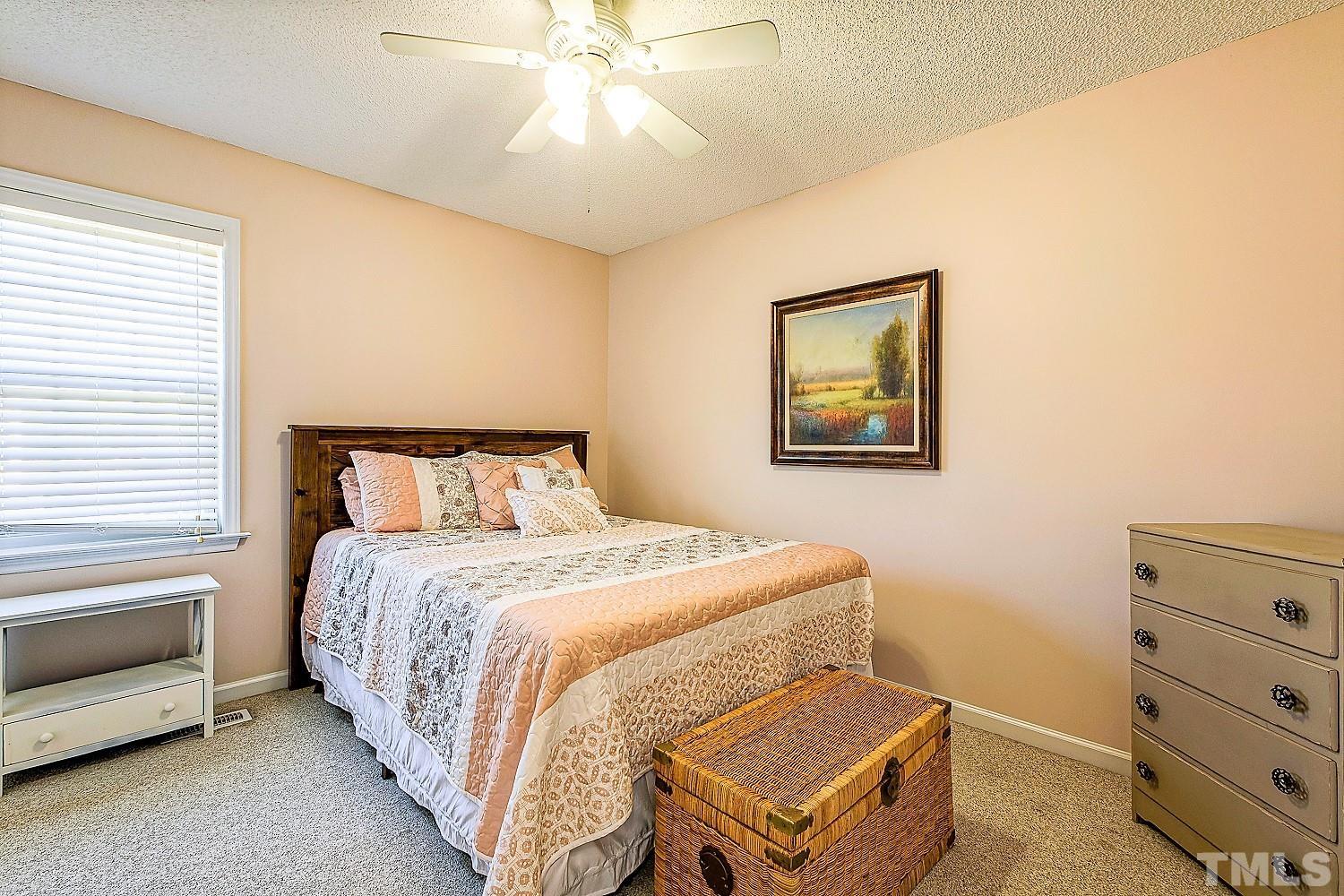 1001 Retriever Lane Raleigh, NC 27603 - Photo 33 of 50 a bedroom with a bed and a chandelier