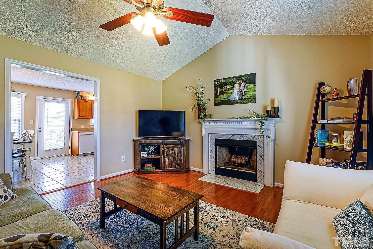 1001 Retriever Lane Raleigh, NC 27603 - Photo 10 of 50 a living room with furniture a flat screen tv and a fireplace