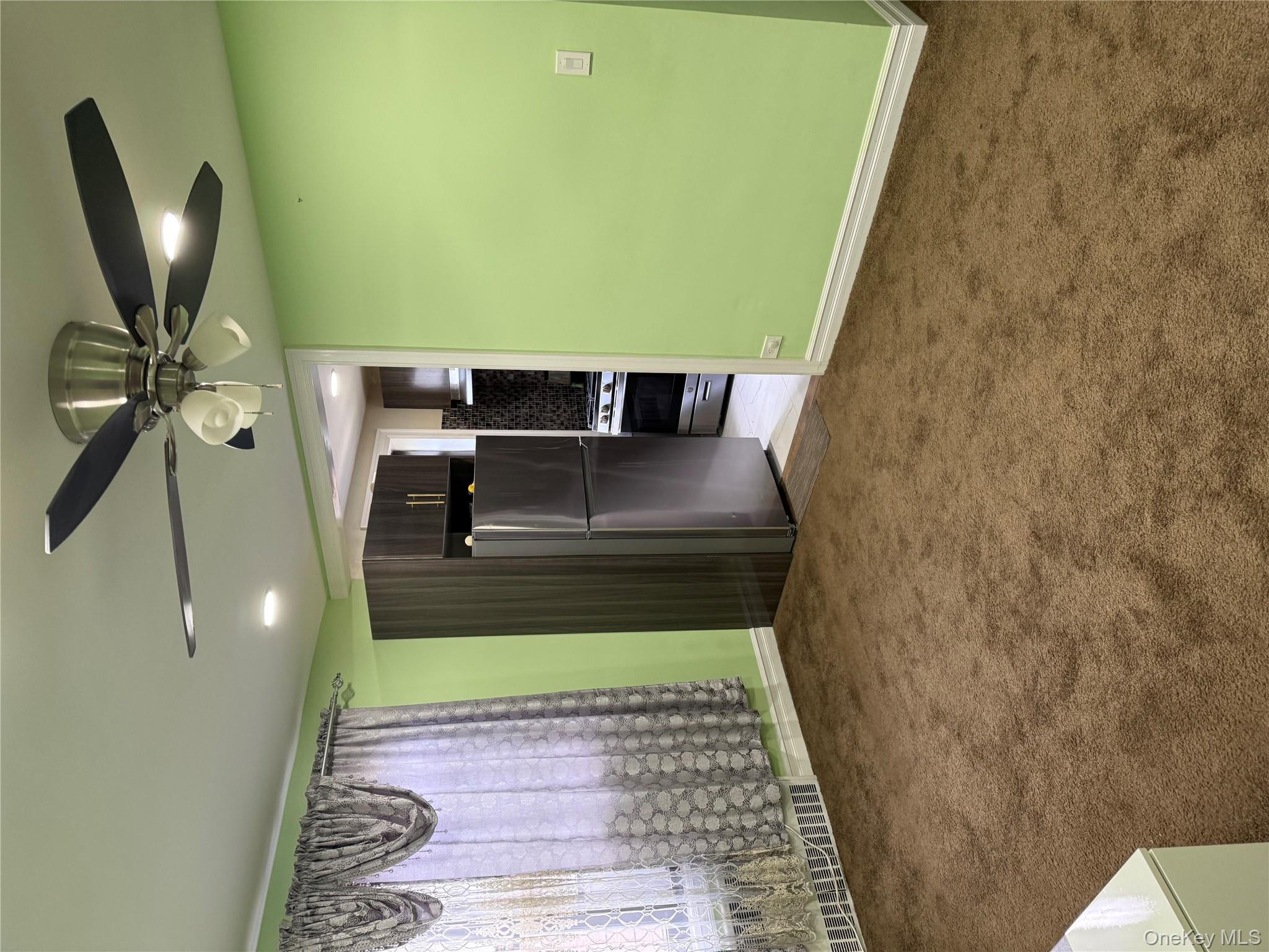 112-30 Northern Boulevard, Unit 4G Queens, NY 11368 - Photo 15 of 18 en empty room with a fan