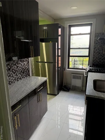 a kitchen with granite countertop a refrigerator a stove and a sink