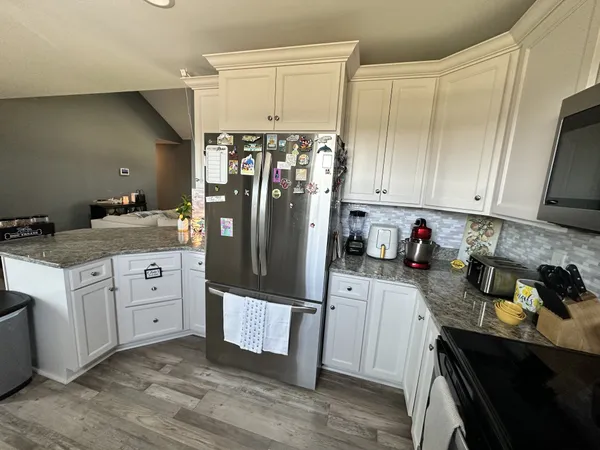 a kitchen with stainless steel appliances kitchen island granite countertop a refrigerator sink and stove