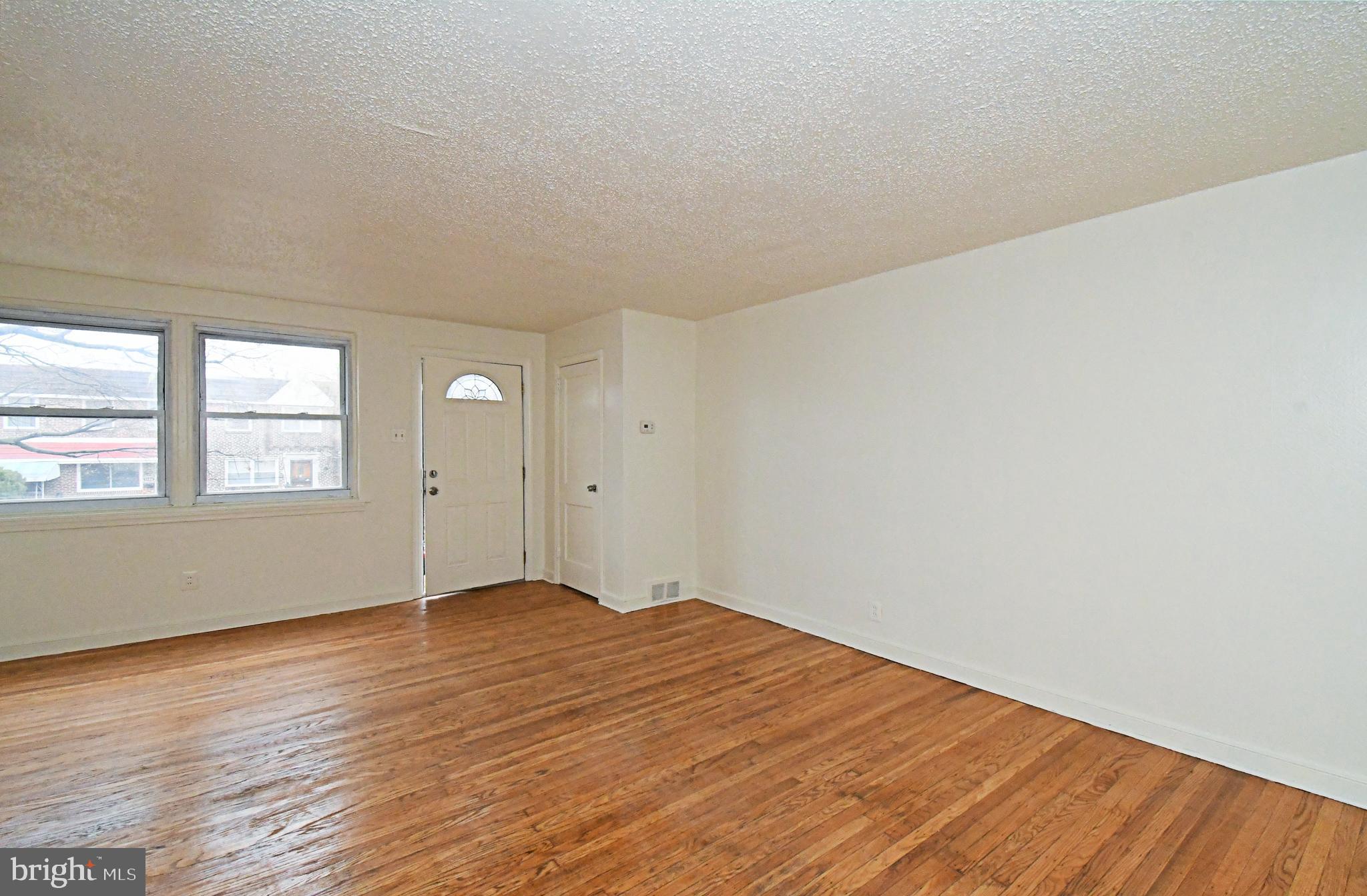 1107 East Sharpnack Street Philadelphia, PA 19150 - Photo 11 of 41 an empty room with wooden floor and windows