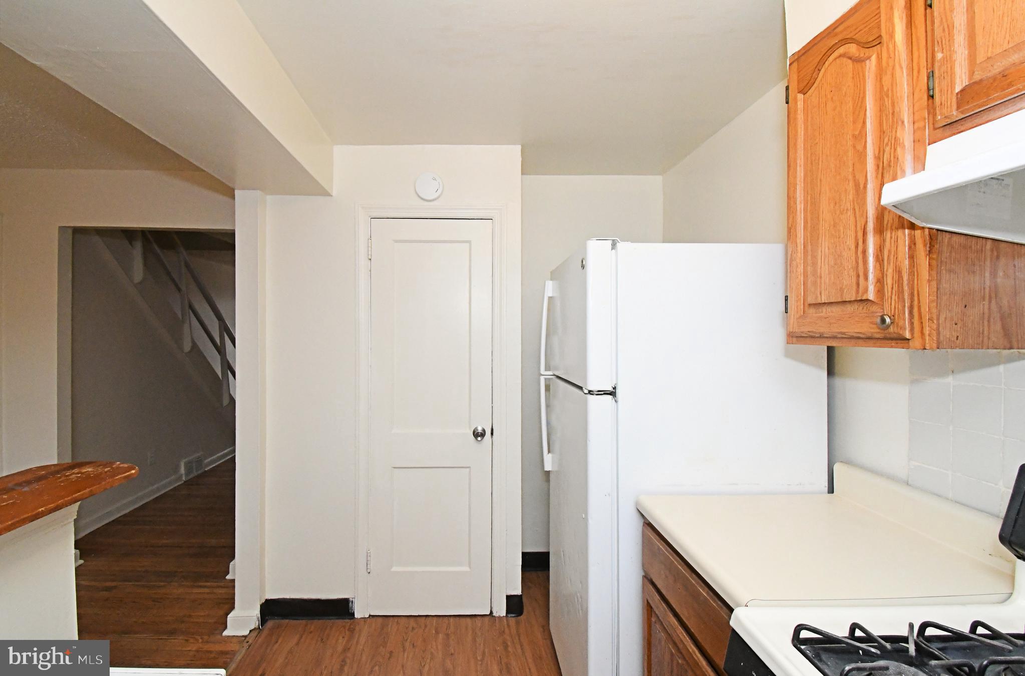 1107 East Sharpnack Street Philadelphia, PA 19150 - Photo 18 of 41 a kitchen with a refrigerator a sink and cabinets
