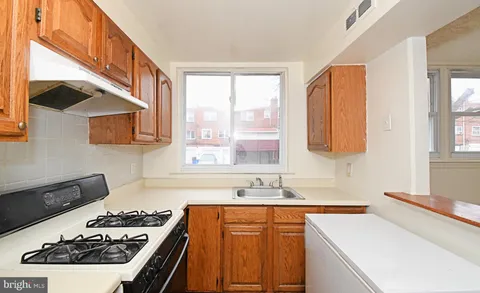 a kitchen with a sink stove top oven and cabinets