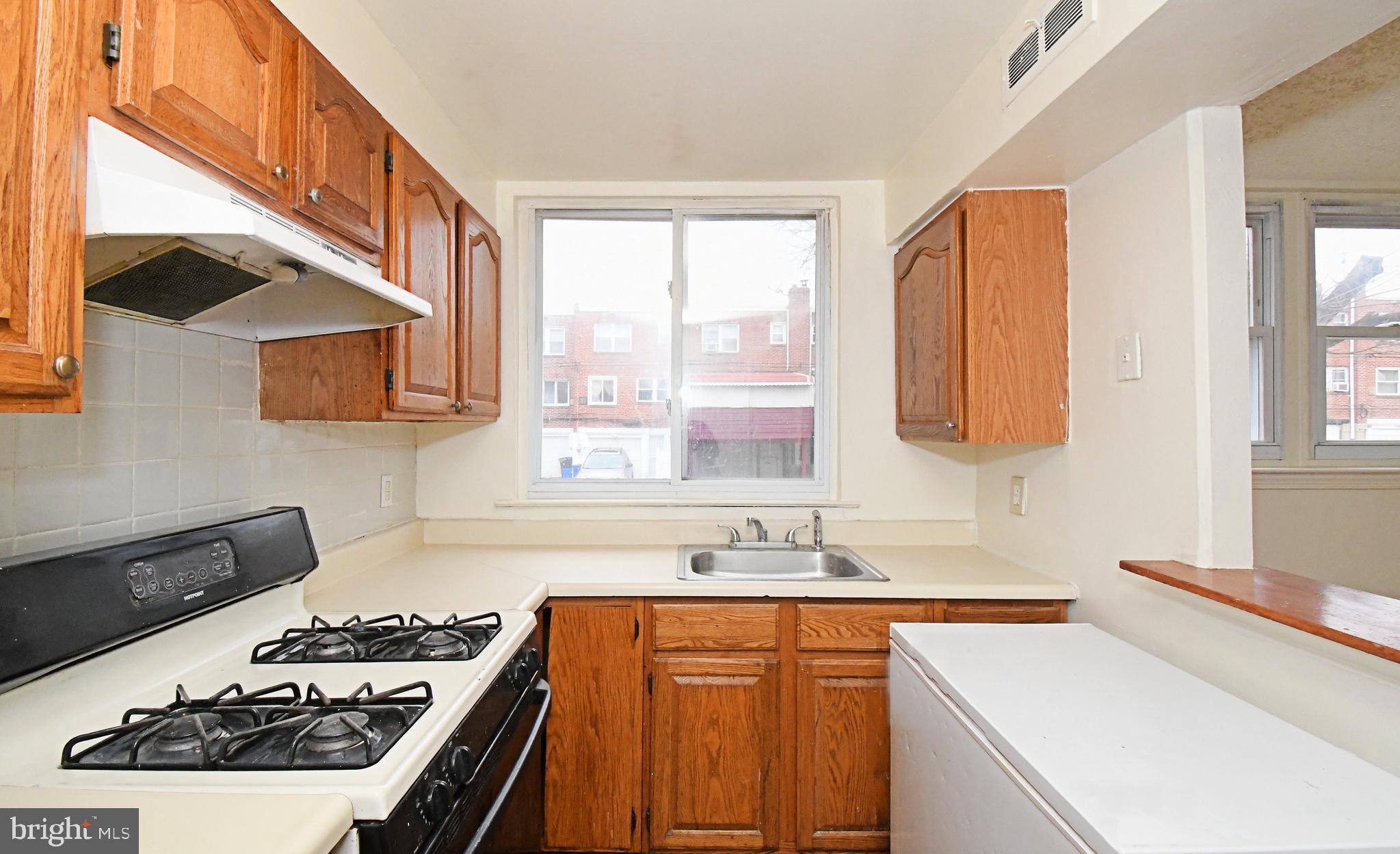 1107 East Sharpnack Street Philadelphia, PA 19150 - Photo 19 of 41 a kitchen with a sink stove top oven and cabinets