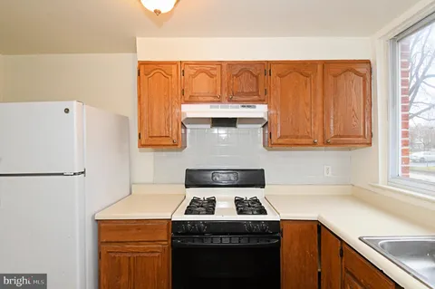 a white stove top oven sitting inside of a kitchen