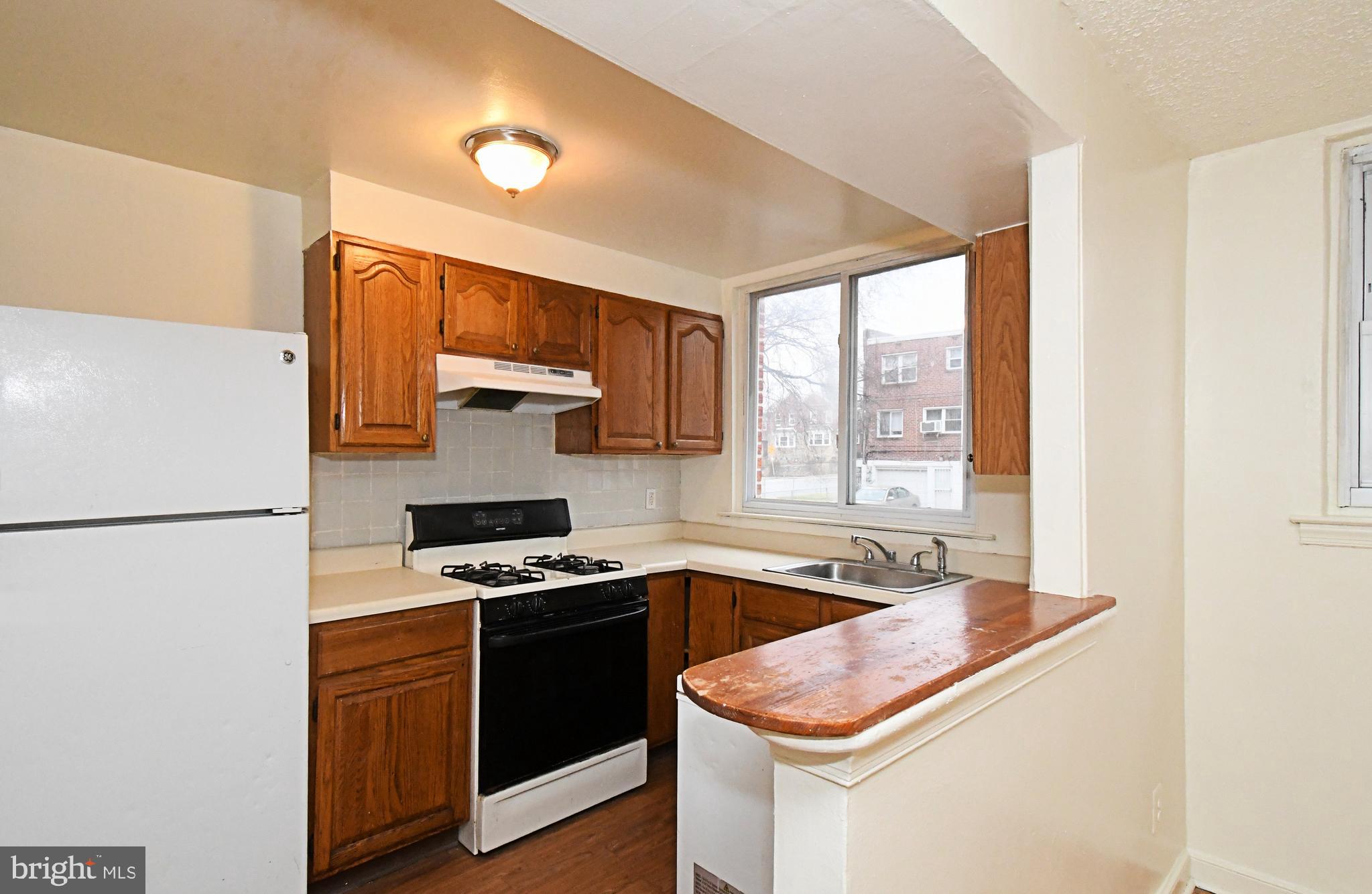 1107 East Sharpnack Street Philadelphia, PA 19150 - Photo 21 of 41 a kitchen with stainless steel appliances granite countertop a sink stove and refrigerator