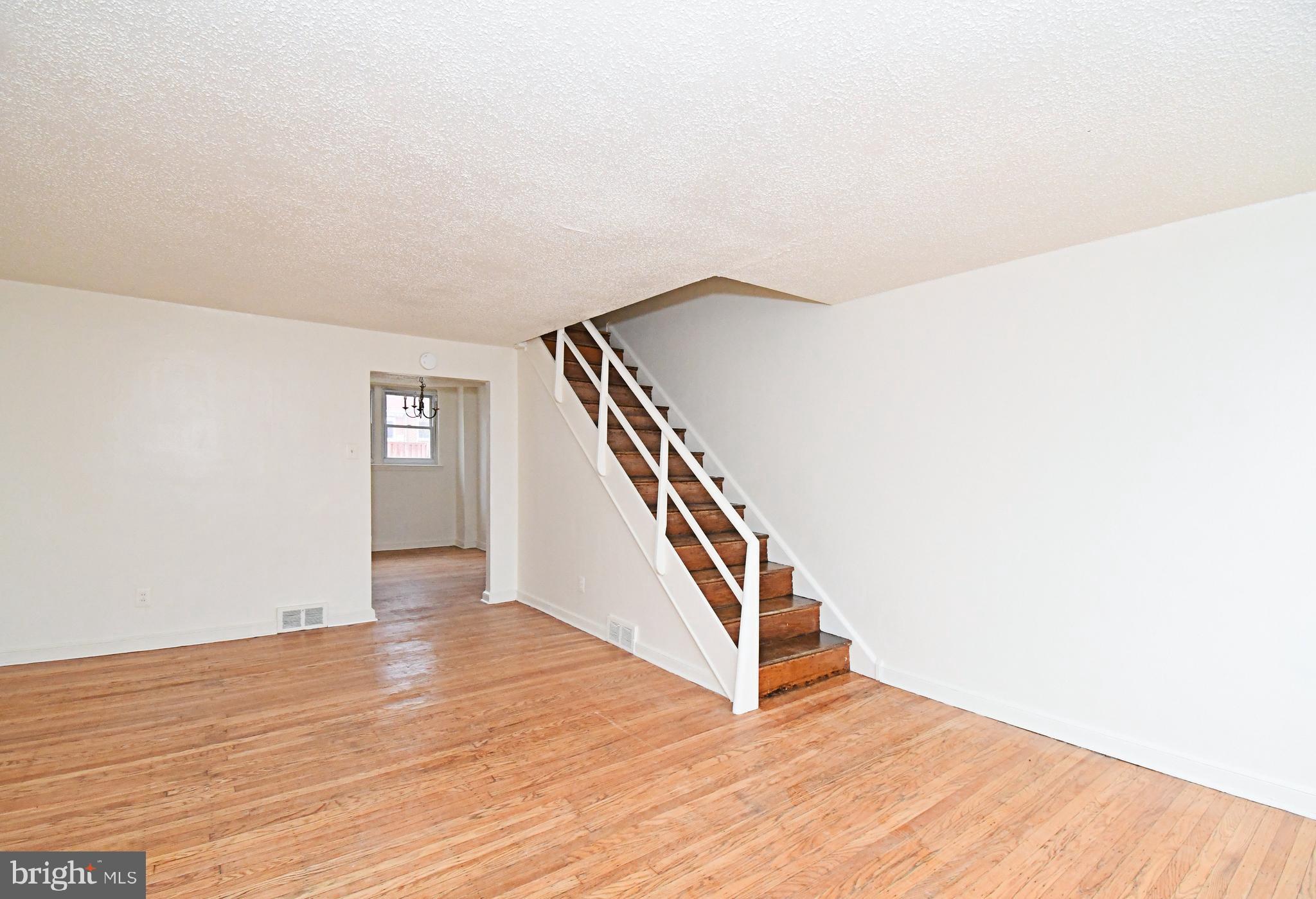 1107 East Sharpnack Street Philadelphia, PA 19150 - Photo 7 of 41 a view of an empty room with wooden floor and stairs