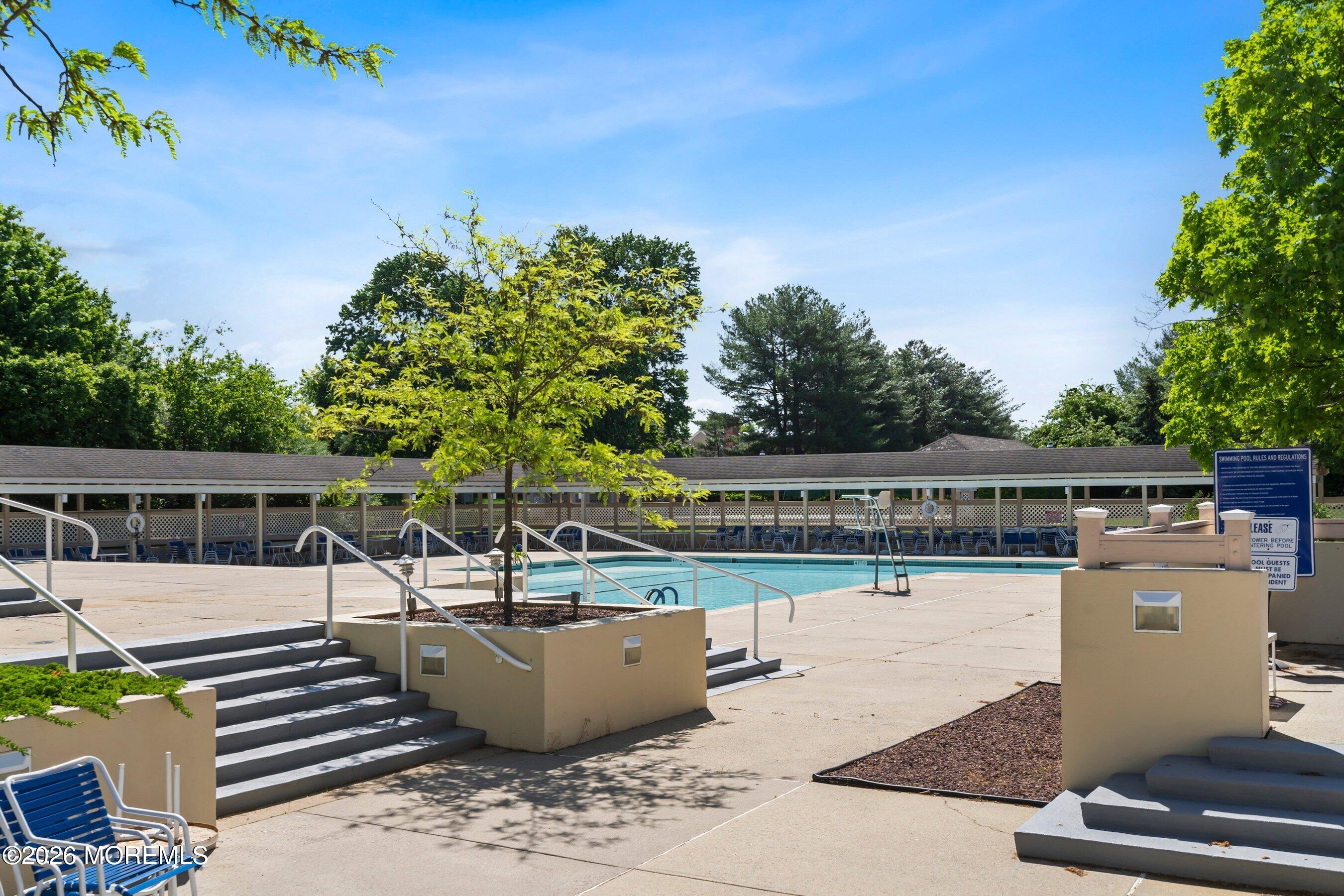 34 B Rutland Lane Monroe Township, NJ 08831 - Photo 36 of 46 a view of a swimming pool with a patio and wooden fence