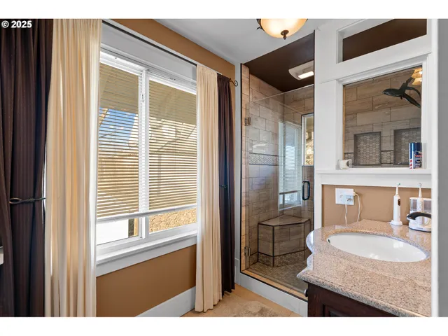 a bathroom with a sink vanity granite tub and a mirror