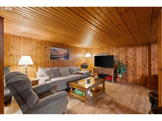 a room with furniture pool table flat screen tv and windows