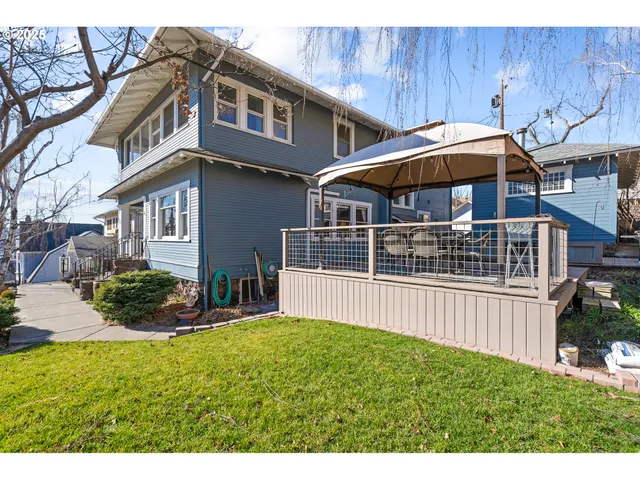 a patio with wooden floor a yard a table and chairs