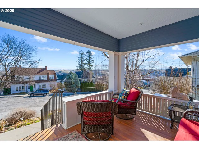 a balcony with wooden floor and outdoor seating