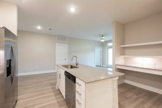 a bathroom with a granite countertop sink a toilet and shower