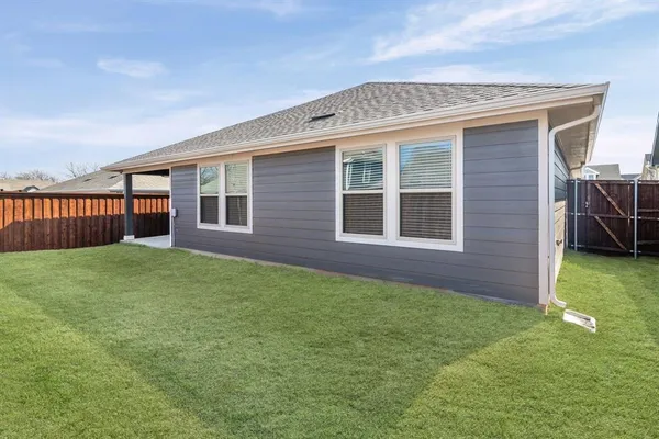 a view of backyard of house with green space