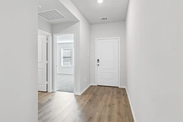 a kitchen with stainless steel appliances granite countertop a sink a stove a refrigerator and island with wooden floor