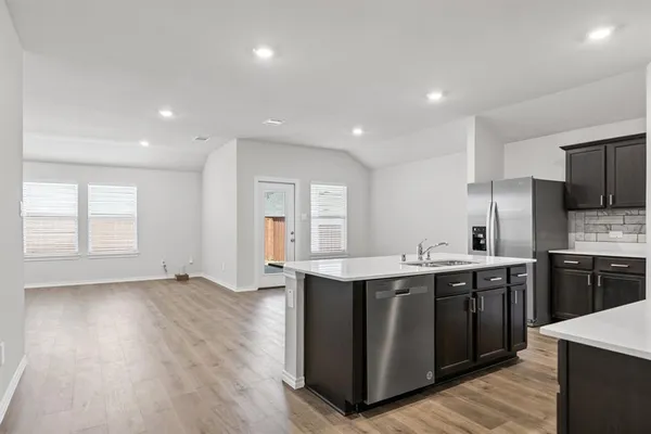 a kitchen with stainless steel appliances granite countertop a sink stove and refrigerator