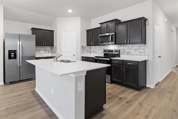 a kitchen with stainless steel appliances a refrigerator and a stove top oven