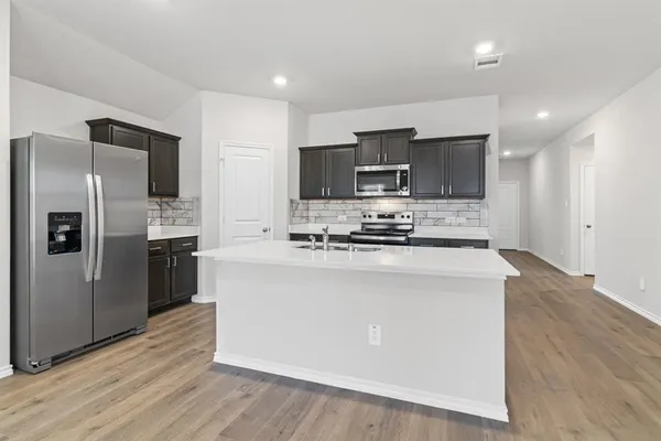 a kitchen with stainless steel appliances a sink stove and refrigerator