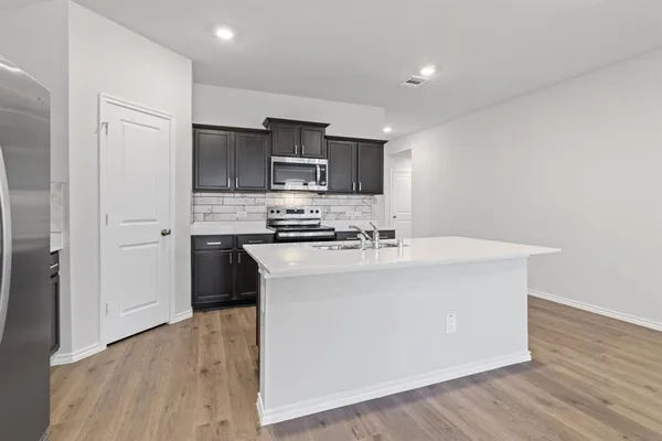 a view of a kitchen with a refrigerator a microwave and a sink
