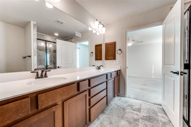 a bathroom with a sink double vanity granite tub shower and a mirror
