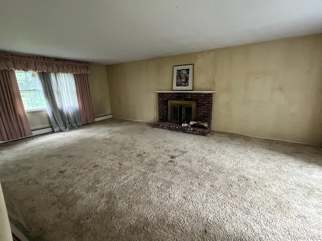an empty room with a fireplace and windows