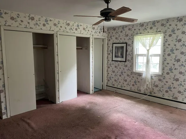 a view of a livingroom with a ceiling fan and window