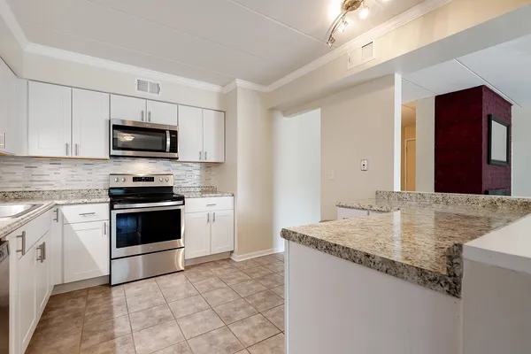 a kitchen with granite countertop a stove and a sink
