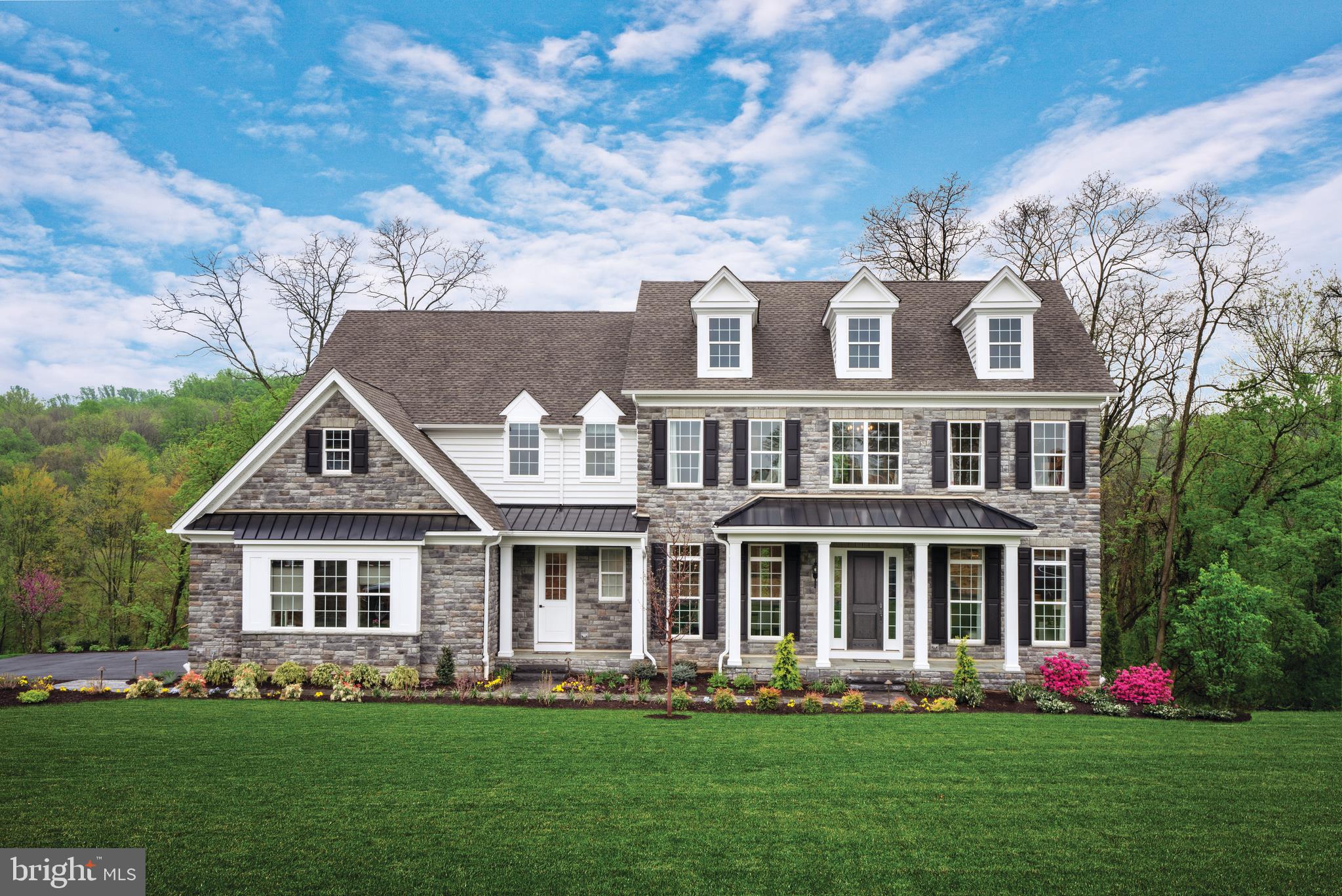 a front view of a house with a garden and plants