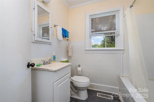 a bathroom with a granite countertop toilet sink and mirror