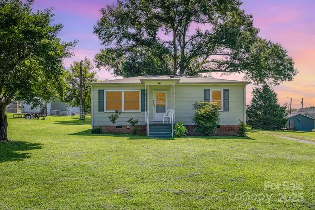 a view of a house with a yard and tree s