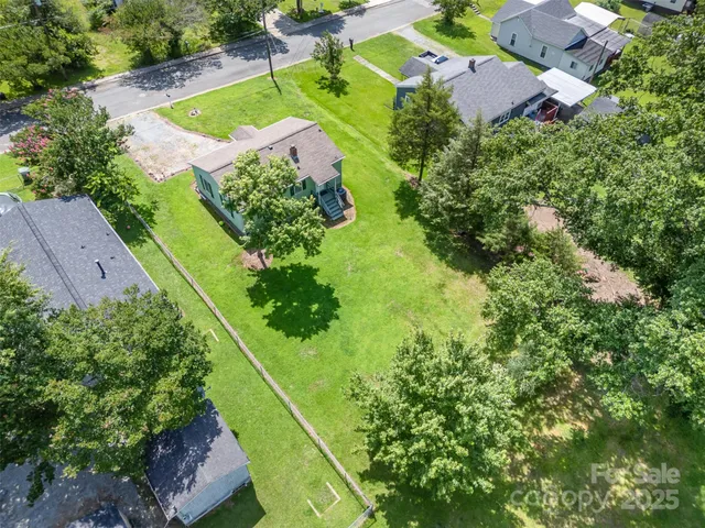 an aerial view of a house with a yard swimming pool outdoor seating