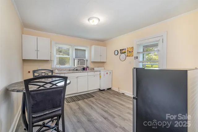 a kitchen with a sink a stove cabinets and wooden floor