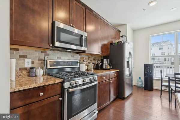 a kitchen with stainless steel appliances granite countertop a stove refrigerator and microwave