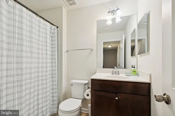 a bathroom with a sink a toilet a mirror and shower curtain