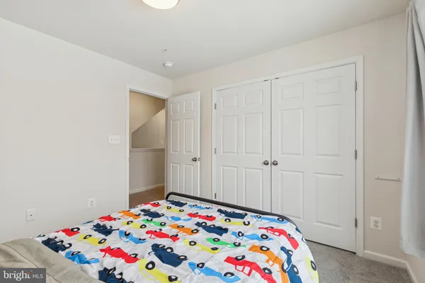 a bedroom with a bed and a lamp on dresser