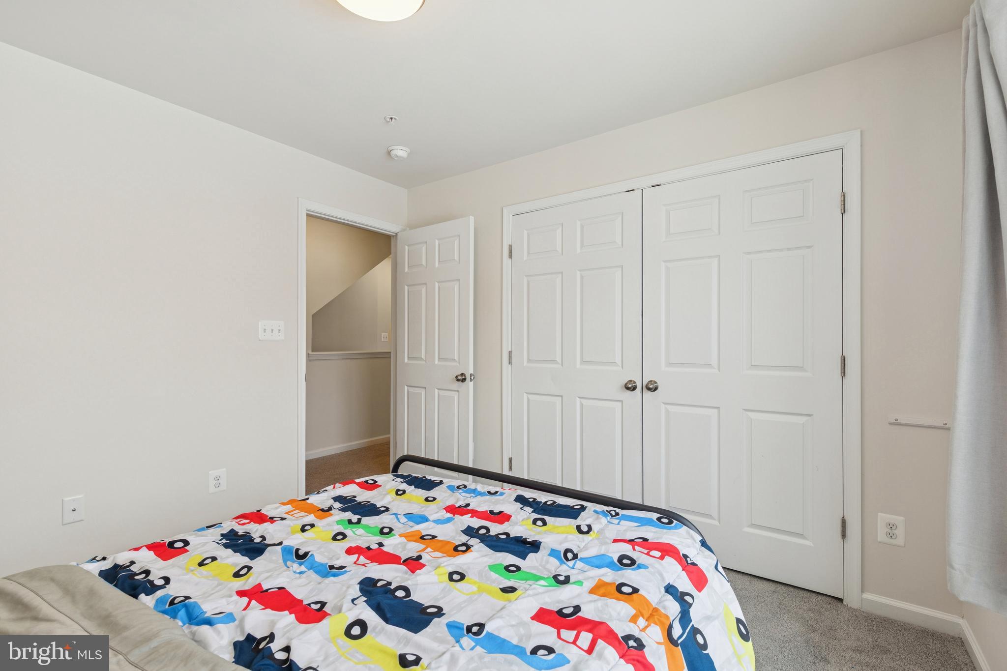 5857 Bella Marie Way, Unit F Frederick, MD 21703 - Photo 23 of 45 a bedroom with a bed and a lamp on dresser