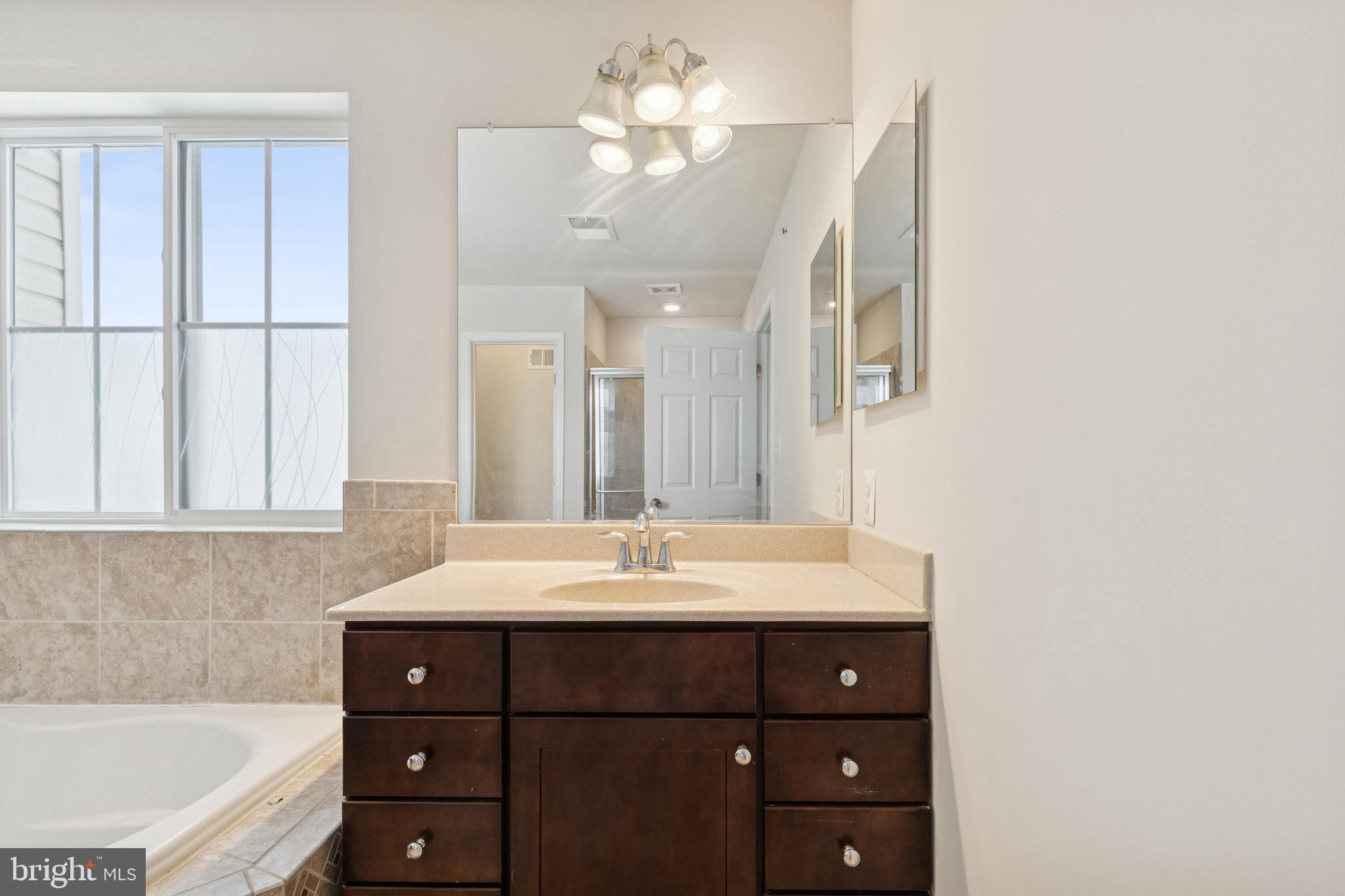 5857 Bella Marie Way, Unit F Frederick, MD 21703 - Photo 33 of 45 a bathroom with a sink vanity tub and a mirror